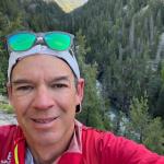 Coach Sandy on a trail run with the Vallecito Creek and San Juan mountains in the background